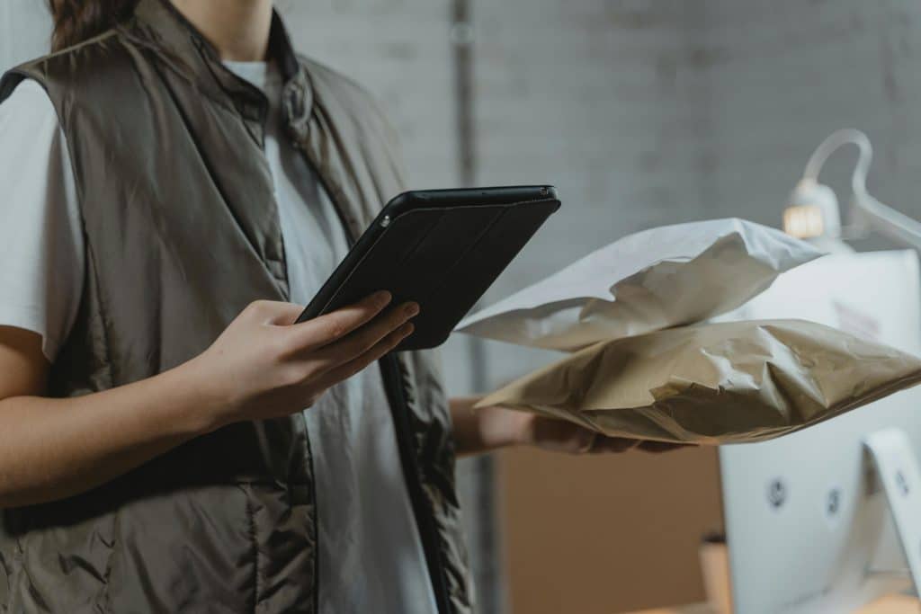 person holding tablet and packages